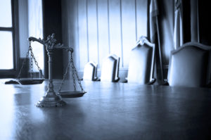 a justice scale sits on a table in front of a courtroom