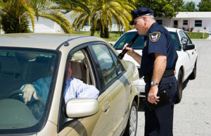 a police officer checking the driver's license of a car