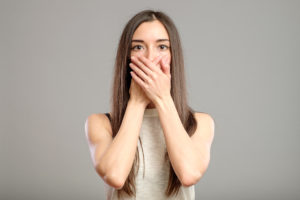 a woman covering her mouth with both hands