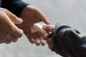 a person handing a small piece of paper to another person