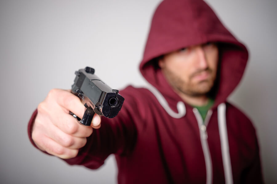 a man in a hoodie holding a gun
