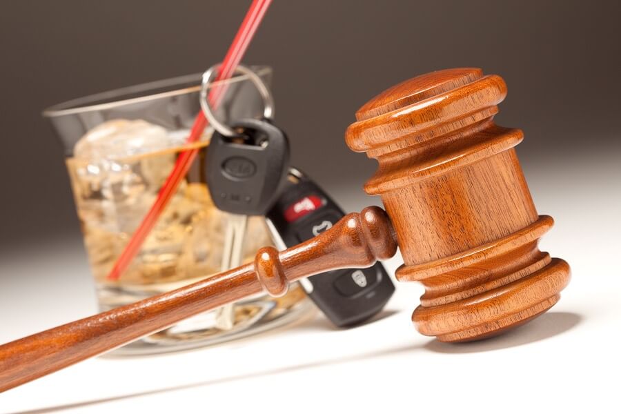 a judge's gavel and a glass of wine next to a car keys
