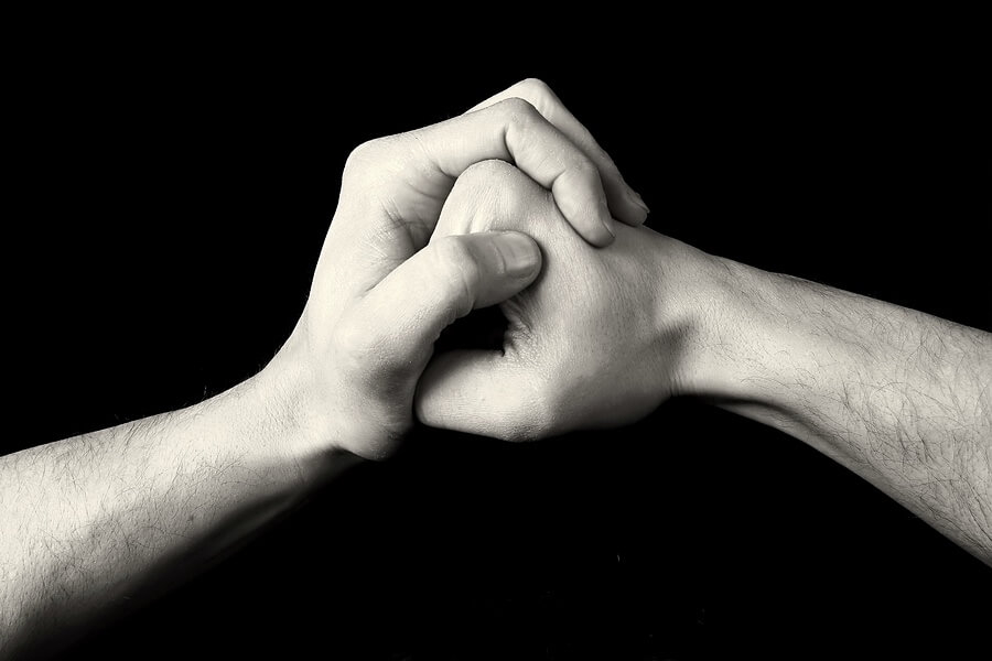two hands are holding each other in a fist