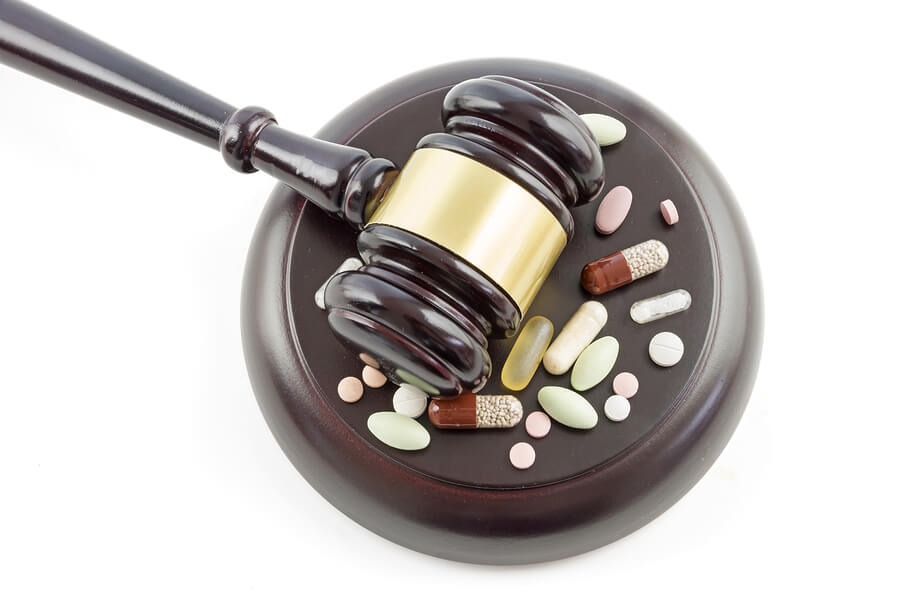 pills and a judge's gavel on a white background