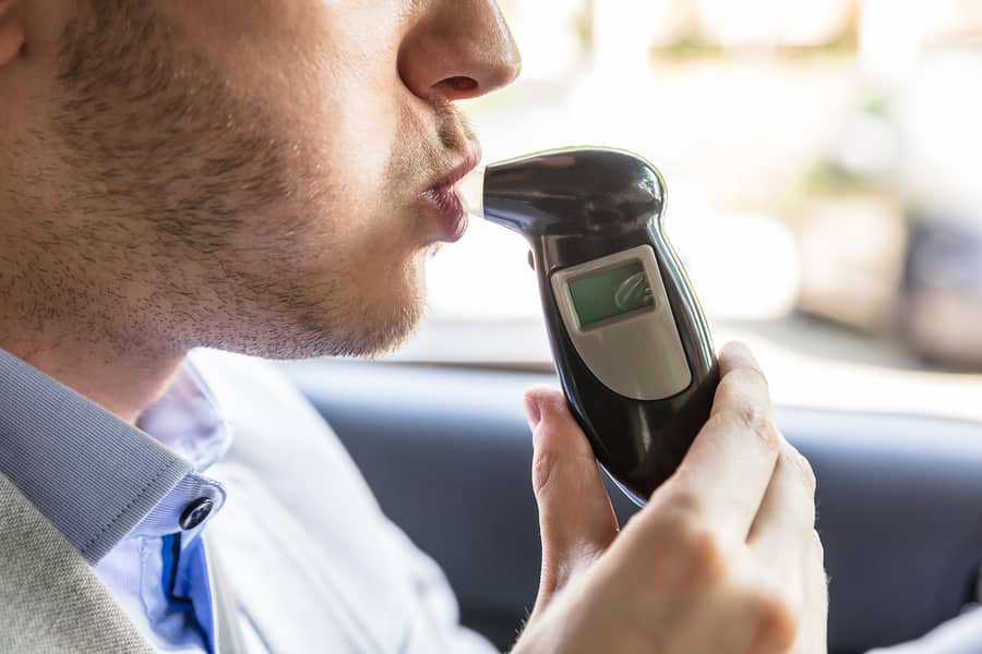 a man is using an electronic device to check his blood alcohol level