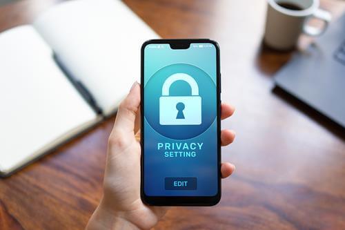 a person holding a smartphone with the privacy settings logo