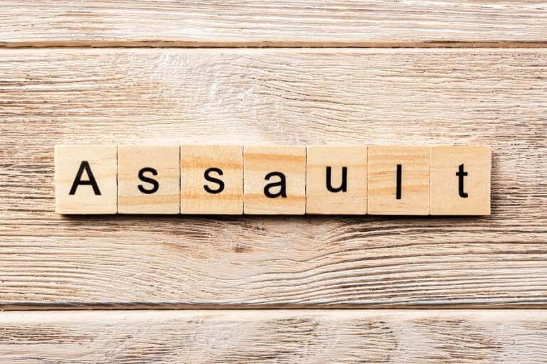 the word assault on wooden background