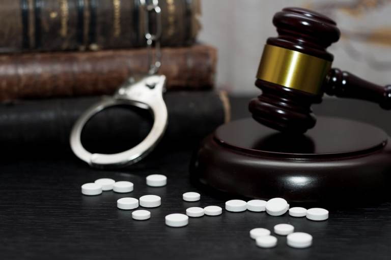 pills and a gavel on a wooden table