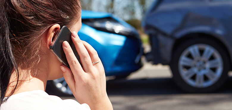 a woman is talking on her cell phone while looking at a car