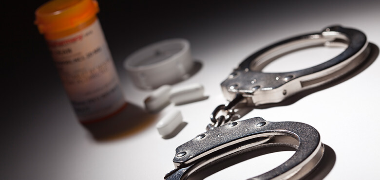 handcuffs and a prescription bottle on a table