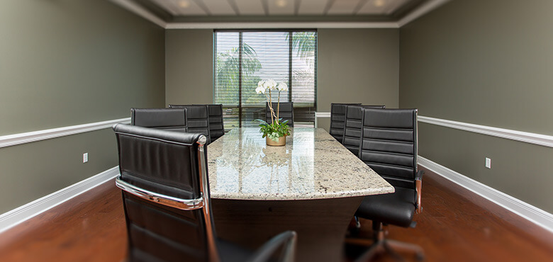 a conference room with a marble table and black chairs