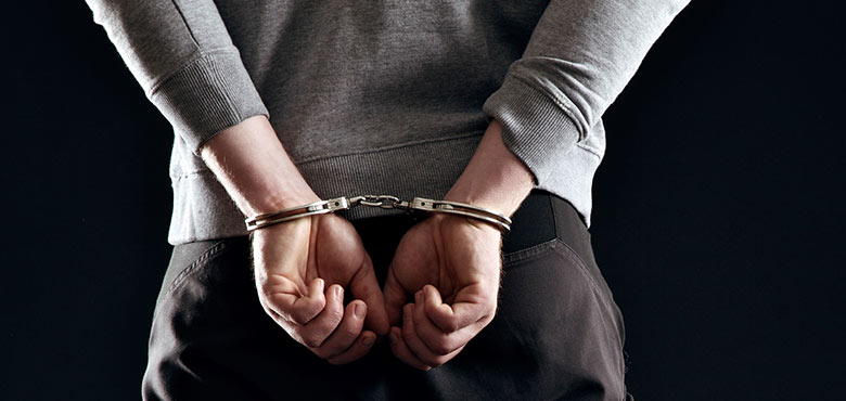 a man in handcuffs is holding his hands behind his back