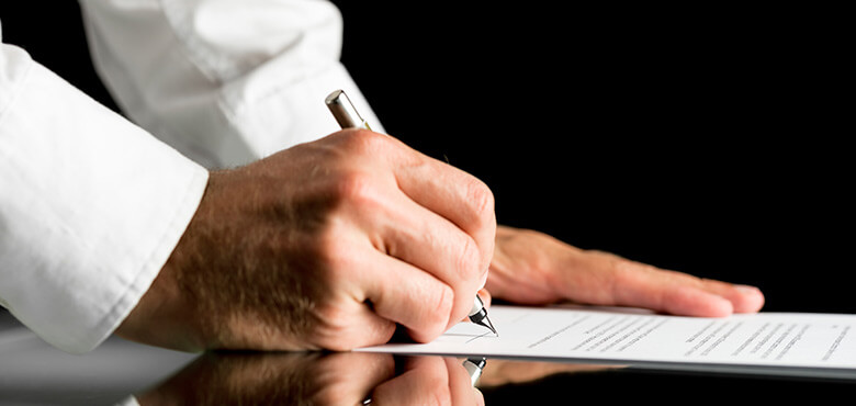 a person signing a document with a pen