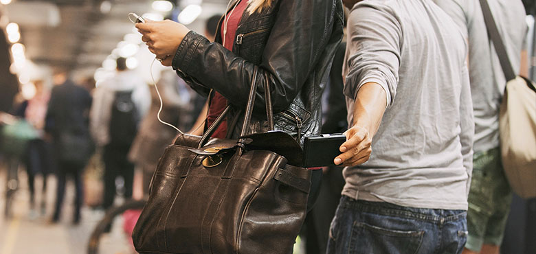 a woman holding a purse and looking at her phone