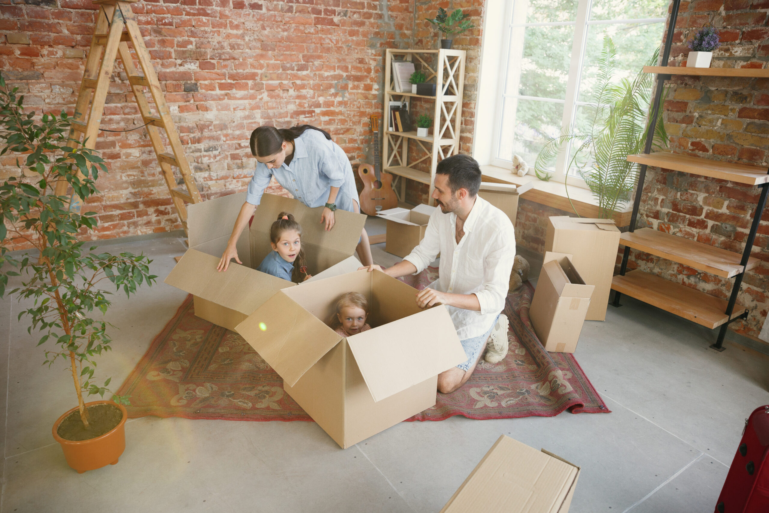 Parents and children packing moving boxes in a home, representing relocating kids during divorce proceedings