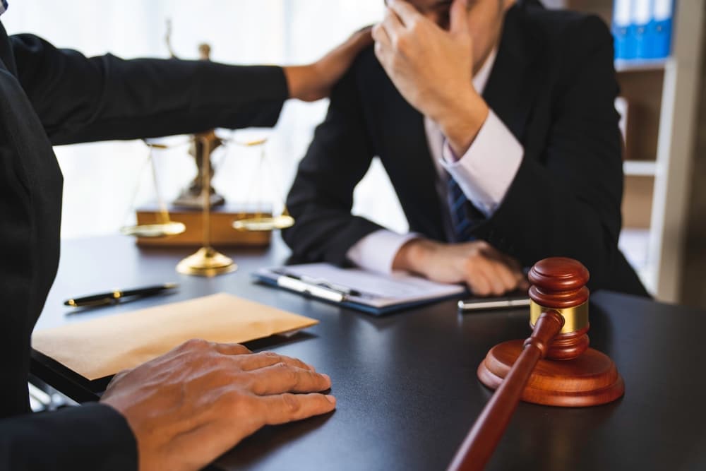 A family law attorney encouraging a client during a litigation consultation in a lawyer's office, representing legal support in family law cases.