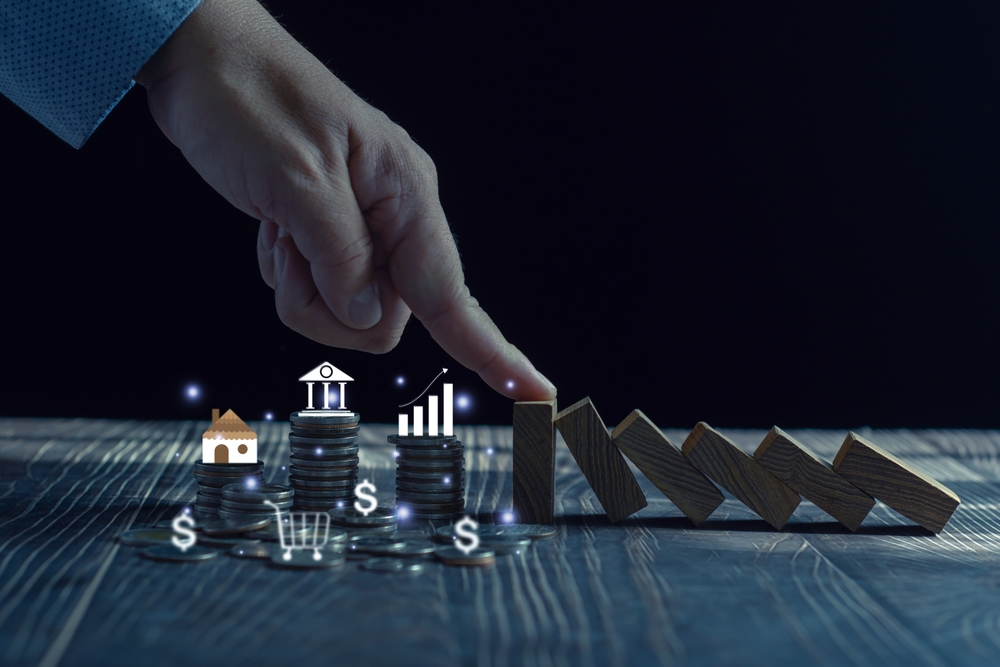 Economic collapse concept, hands stop domino crisis effect, financial and banking problems, recession, financial crisis, bad debt, inflation and interest rates