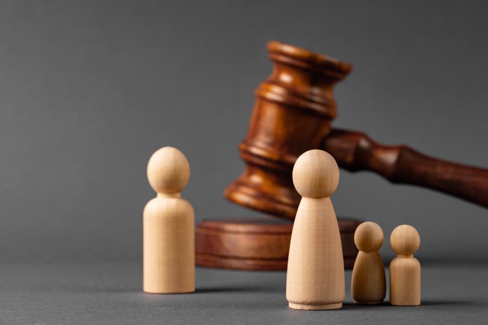 Wooden toy family and judge mallet. Family divorce concept