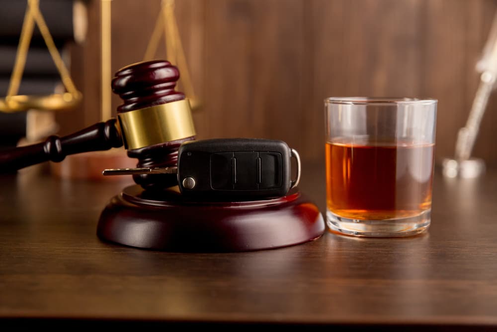 Whiskey with car keys and handcuffs. Concept for drinking and driving