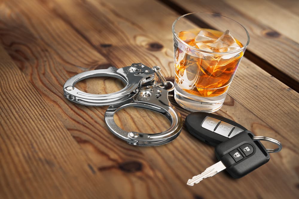 Whiskey with car keys and handcuffs concept for drinking and driving