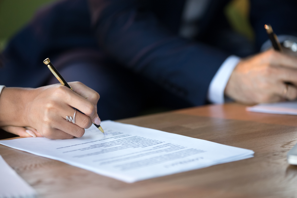 Close-up of a couple signing legal documents for spousal support